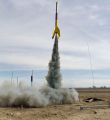 The rocket lifting off on a smoky motor. The unpainted repair is seen in the middle of the rocket.