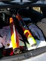 A photo of the lower and middle airframe segments of the orange rocket loaded in the back of a VW hatchback.